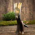 Load image into Gallery viewer, Drikkehorn Yggdrasil U. Mønster, med et indviklet Yggdrasil-design, står stolt oprejst på endnu et drikkehorn mod en rustik træbaggrund. Grønt i kulissen tilføjer et naturligt touch til denne vikingemarkedsinspirerede scene.