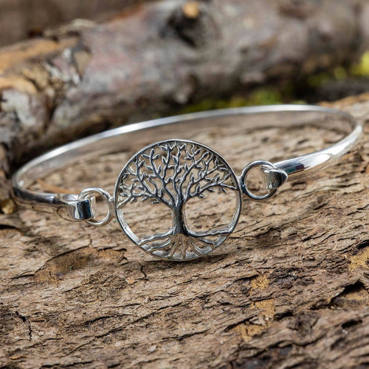 Et Armbånd Bangle Livets Træ 925s Sterling Sølv har en cirkulær charme med et indviklet livets træ-design, sat mod en tekstureret træoverflade prydet med bark og mos, der fremmaner essensen af Vikingetiden.