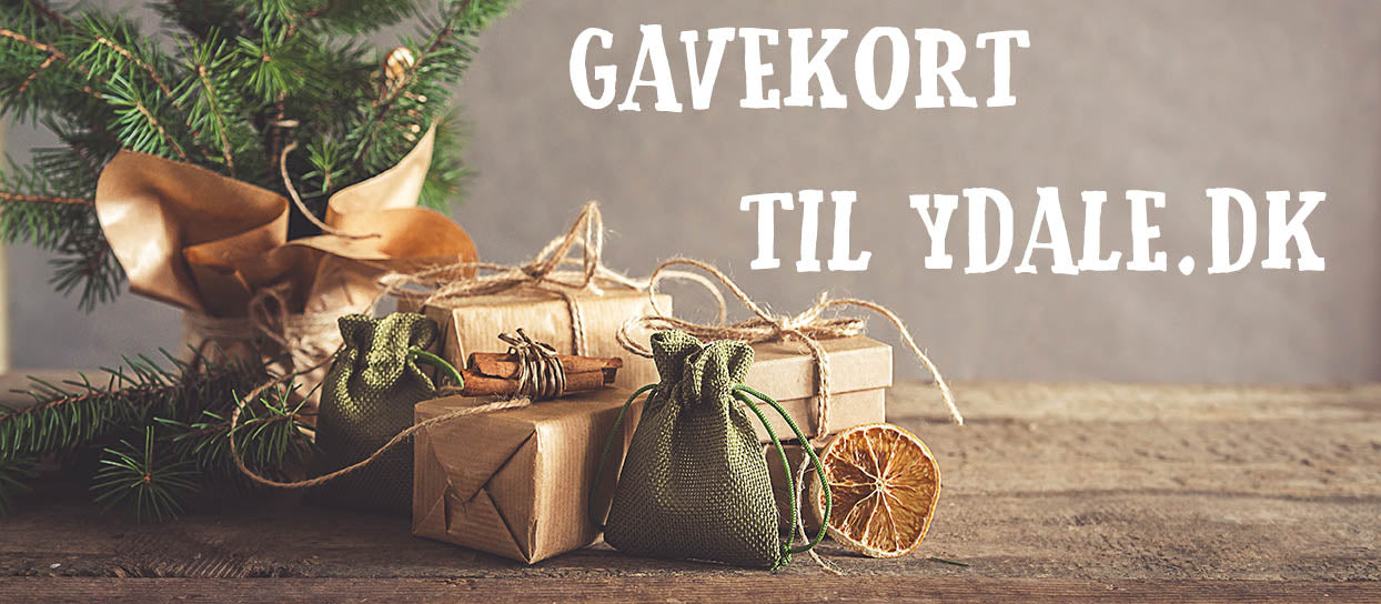 Et festligt arrangement af indpakkede gaver og en tørret appelsinskive under et lille juletræ med teksten "Gavekort til ydale.dk - 500kr" i rustikke, hyggelige rammer.