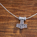 Load image into Gallery viewer, En sølv Halskæde Ankerkæde 925s Sølv 2 mm halskæde med et vedhæng, der er indviklet designet som Thors hammer (Mjölnir) med keltiske knudemønstre. Ægte 925s Sterling sølv vedhæng hænger i en løkke med lignende design og hviler på en træoverflade. Fås i forskellige længder på en ankerkaede.
